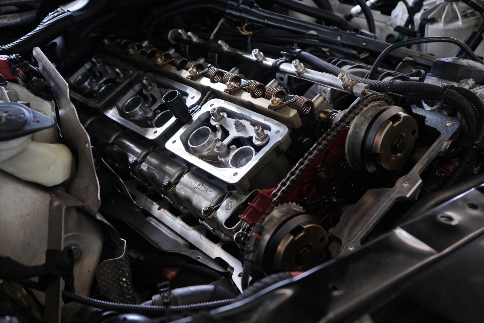 Valve cover removed from car engine during gasket oil leak repair
